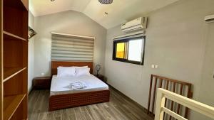 a small bedroom with a bed and a window at Villa La Lagune in Mbour