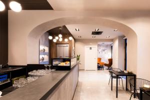 ein Restaurant mit einer Theke mit einer Bar mit Stühlen in der Unterkunft KT exclusive hotel in Cagliari