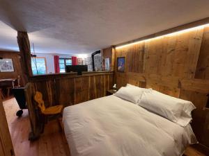 a bedroom with a bed with a wooden wall at Baita Meyen - Val Ferret in Courmayeur