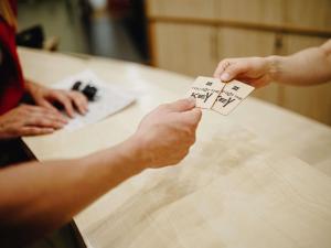 a person holding up a piece of paper on a table at Ibis Győr in Győr