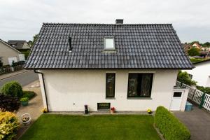a white house with a black roof at Ferienhaus Kottmann in Bremerhaven
