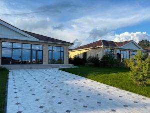 a house with a stone driveway in front of it at Вип Вилла у берега in Chon-Sary-Oy