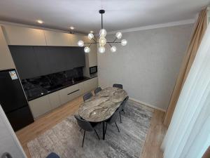 a dining room with a table and chairs and a chandelier at Вип Вилла у берега in Chon-Sary-Oy