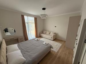 a white bedroom with a bed and a couch at Вип Вилла у берега in Chon-Sary-Oy