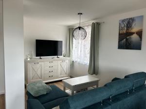 a living room with a blue couch and a tv at Loggia in Stockach