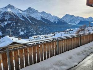 Ein Bahnhof mit schneebedeckten Bergen im Hintergrund in der Unterkunft Chasa Foppa in Scuol