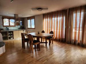 eine Küche und ein Esszimmer mit einem Holztisch und Stühlen in der Unterkunft Chasa Foppa in Scuol + 9 Fotos