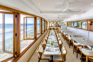 a dining room with tables and chairs and the beach at Surf & Sand Laguna Beach in Laguna Beach