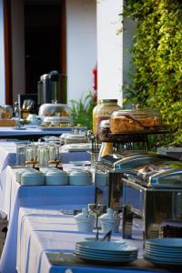 a row of tables with plates and dishes on them at Hotel Terra in Arequipa