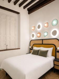 a bedroom with a white bed and a window at Hotel Casa Beatas in Málaga +16 photos