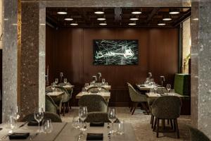 a restaurant with tables and chairs and a painting on the wall at Romègas Hotel in Valletta