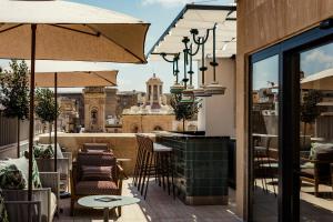 a view from the rooftop of a restaurant with tables and umbrellas at Romègas Hotel in Valletta
