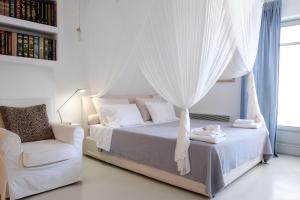 a white bedroom with a bed and a chair at The Ioulis Pool in Ioulis +27 photos