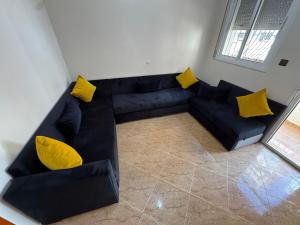 a black couch with yellow pillows in a living room at Larache City Apartment in Larache