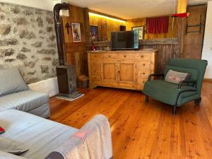 a living room with a couch and a tv at Baita Meyen - Val Ferret in Courmayeur