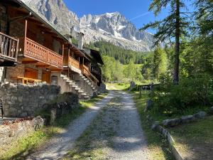a dirt road next to a building with a mountain at Baita Meyen - Val Ferret in Courmayeur