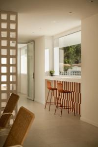 a kitchen with chairs and a bar with a window at Almar Suites Daimús in Daimuz