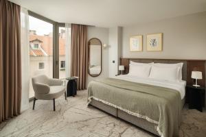 a bedroom with a bed and a chair and a window at Armerun Hotel Rijeka in Rijeka +60 photos