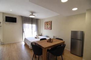 a bedroom with a bed and a table and a refrigerator at RNET - Apartments Roses Centre in Roses