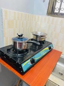 a stove with two pots and pans on top of it at Zarex homes 1 in Mbale