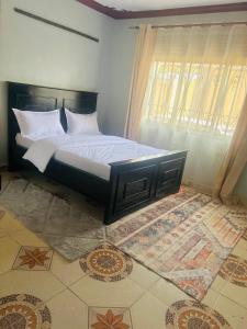 a bedroom with a large bed with a window at Zarex homes 1 in Mbale
