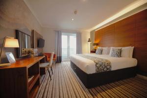 ein Hotelzimmer mit einem großen Bett und einem Schreibtisch in der Unterkunft Highfield Hotel in Houghton le Spring