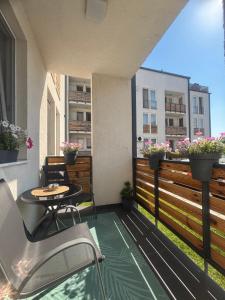 a balcony with a table and chairs and a building at Apartament Bella in Târgu-Mureş