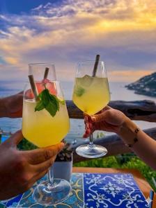 two people holding up glasses of drinks at a table at Casa San Michele in Minori