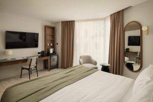 a hotel room with a large bed and a mirror at Armerun Hotel Rijeka in Rijeka