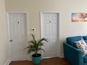 a living room with a blue couch and a plant at CaneView Properties - 1 in Irvington