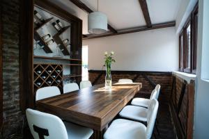 a dining room with a wooden table and white chairs at Vikendica Forest Mansion Surčin in Progar