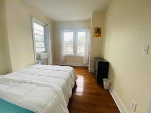 a bedroom with a large white bed and two windows at CaneView Properties - 1 in Irvington