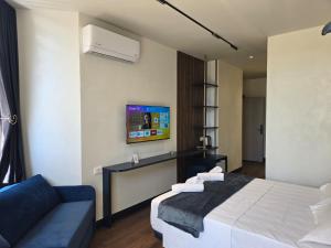 a bedroom with a bed and a tv on the wall at SOLs Center Rooms in Tirana