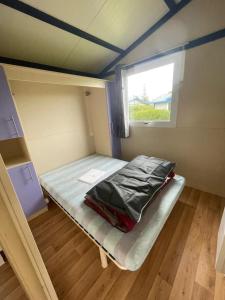a small bed in a small room with a window at Camping 3 étoiles - Piscine - ccbgaia in Châtel-Chéhéry