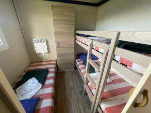 two bunk beds in a small room with a lamp at Camping 3 étoiles - Piscine - ccbgaia in Châtel-Chéhéry +54 photos