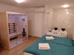 a bathroom with a bed and a shower and a tub at Apartment and Studios Jelovca & Wellness in Radovljica