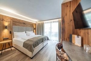 a hotel room with a bed and a television at Hotel Stern in Längenfeld
