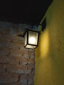 a light on the side of a brick wall at Casaraosete7 in Salvador