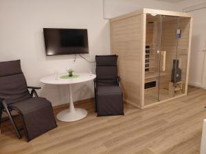 a room with a table and chairs and a tv at Apartment and Studios Jelovca & Wellness in Radovljica
