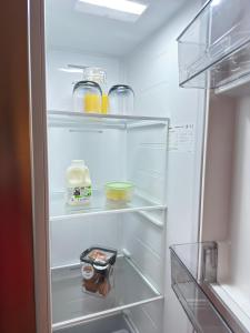 a refrigerator with its door open with food in it at The Old Laundry in Rye
