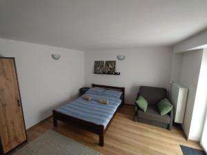 a room with a bed and a couch and a chair at Pokoje Gościnne u DORIS in Stegna