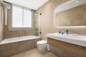 a bathroom with a sink and a tub and a toilet at Santa Barbara Residences by IDILIQ in Fuengirola