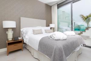 a bedroom with a white bed and a large window at Santa Barbara Residences by IDILIQ in Fuengirola +46 photos