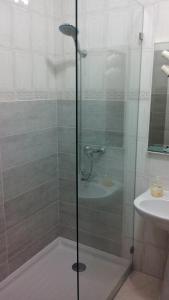 een douche met een glazen deur naast een wastafel bij Apartamento Tavira in Tavira
