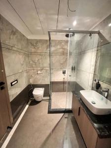a bathroom with a shower and a toilet and a sink at The Koi Boutique Hotel in Gurgaon +62 photos