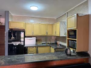 a kitchen with yellow cabinets and a counter top at Marina Blu Blumar Chalet in Ain Sokhna