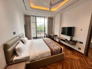 a bedroom with a bed and a flat screen tv at The Koi Boutique Hotel in Gurgaon