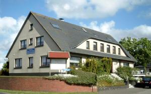 une maison avec un toit gris dans une rue dans l'établissement Hannover Nr.4, à Carolinensiel