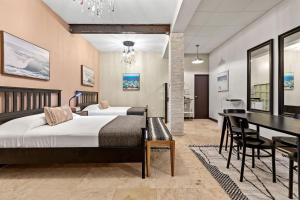 ein Schlafzimmer mit zwei Betten und einem Esstisch in der Unterkunft Rincon Plaza Hotel in Rincon