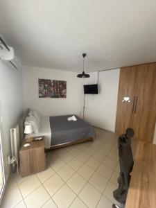 ein Schlafzimmer mit Bett, Schreibtisch und Fernseher in der Unterkunft Oasi studio in Bendevís